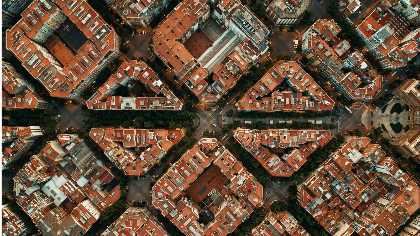 Overhead aerial view of a city grid of chamfered blocks with red-tiled rooftops